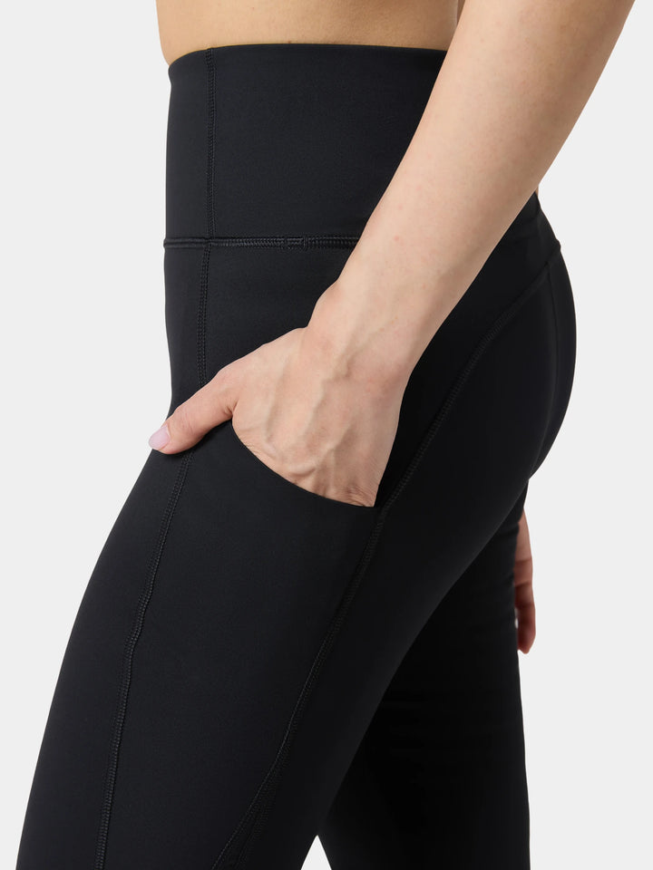 A hand in the side pocket of the Flared Motion Legging in Obsidian Black