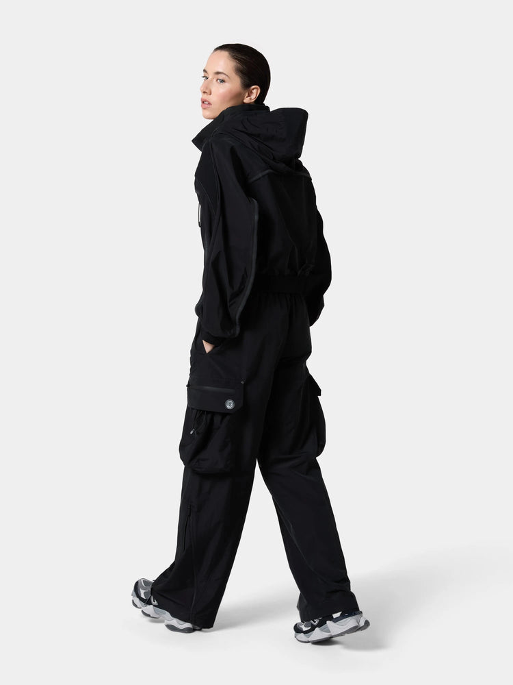 The Obsidian Black windbreaker from behind, mid-stride, walking away