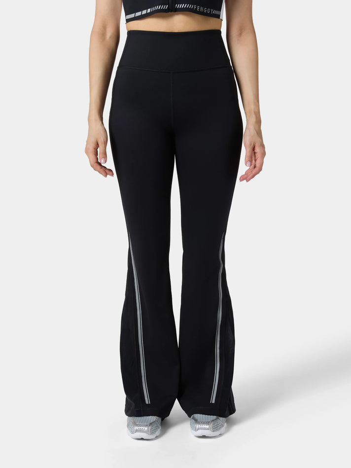 Fenggy Flared Motion Legging in Obsidian Black, full figure on a pale studio ground