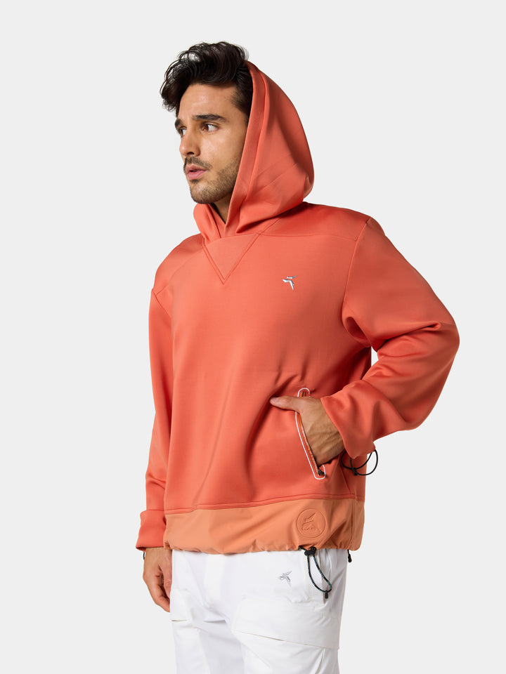 The Solar Ember hoodie worn with the hood up, a hand in the pocket, head to hip