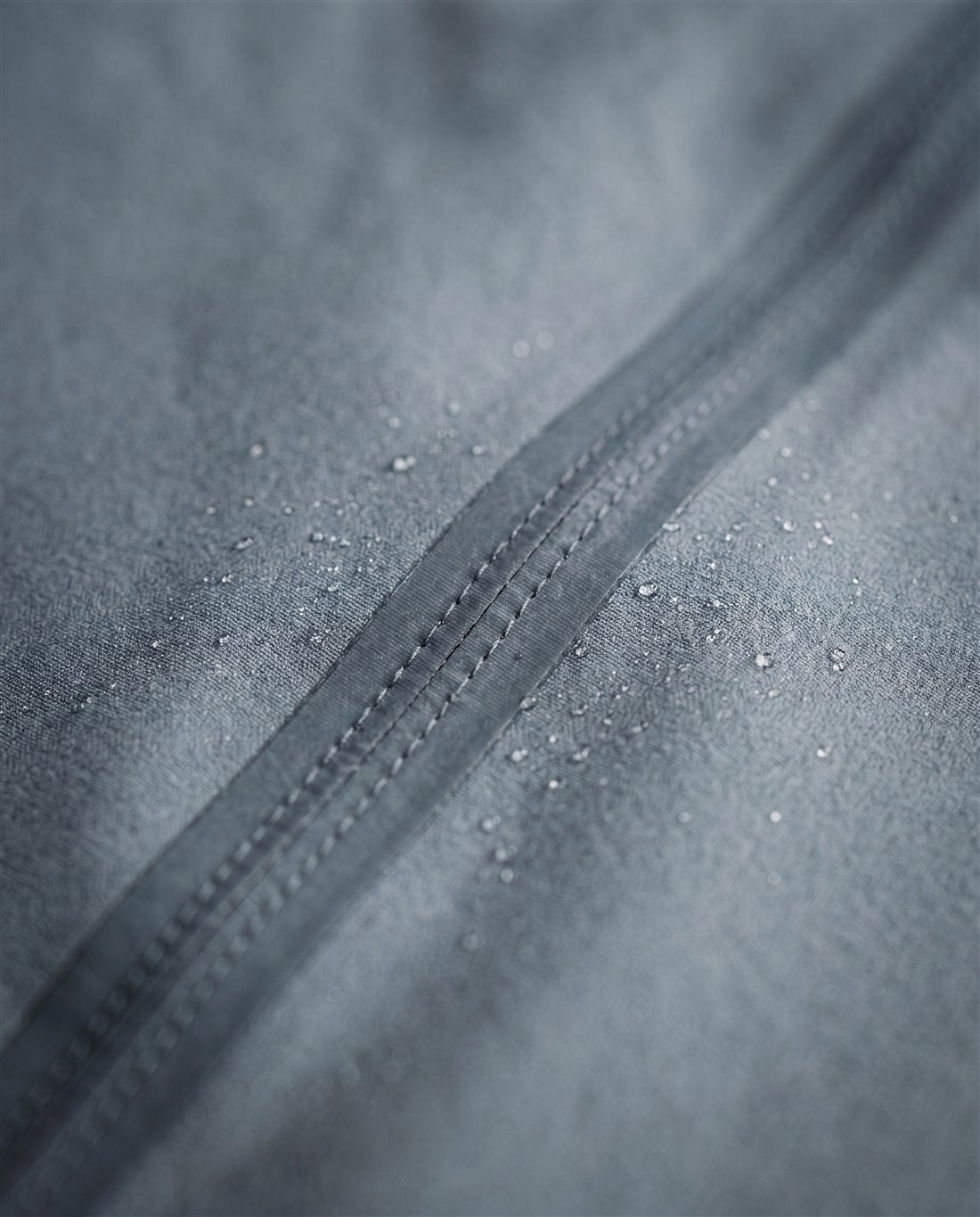 Bonded, taped seams on a matte technical shell, sealed against weather